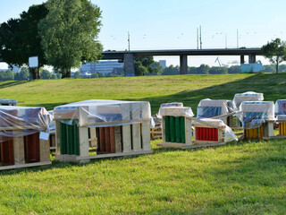 landscape shot 
capturing a long line of pyrotechnic launch 
racks positioned across an open grassy 
riverbank field. The colorful mortar shells 
inside their wooden support frames are 
draped in cle