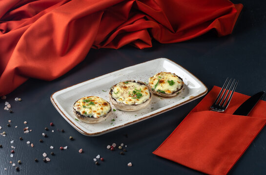Georgian cuisine: Close up mushrooms baked with cheese suluguni on ketsi