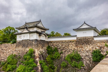 Naklejka premium Elevated stone embankment surrounding Osaka Castle in Osaka Japan during calm overcast weather, Osaka Japan
