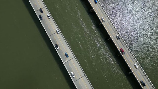 Vertical drone view of the Chesapeake Bay Bridge in Maryland, showing two-way traffic flowing in opposite directions as vehicles cross the span over the Chesapeake Bay