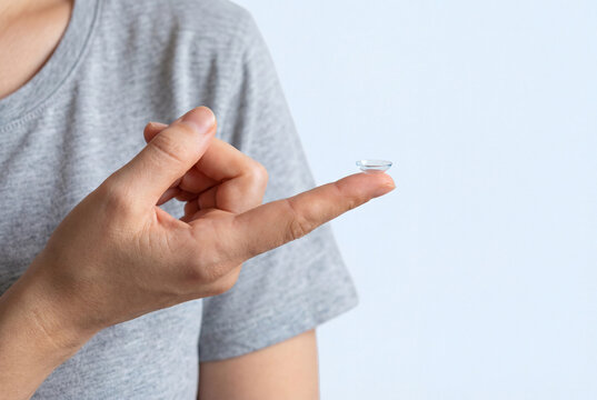 Close up of person holding soft contact lens on index finger for vision correction