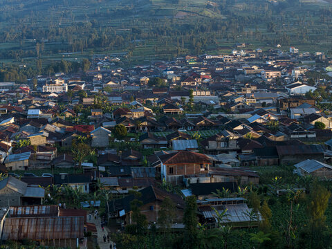 Aerial view of Garung village featuring dense residential houses and lush agricultural fields in Kecamatan Kalikajar, Jawa Tengah, Indonesia.