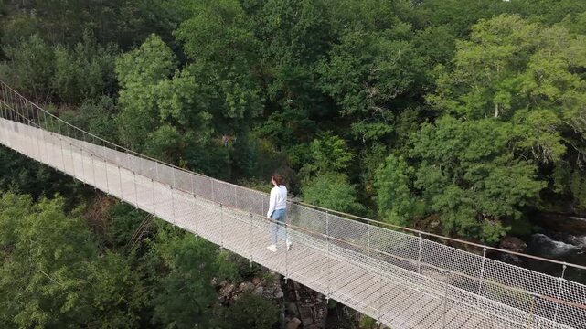 Suspension bridge connecting forest banks over the lerez river in galicia, spain