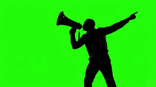 Silhouette of a man shouting into a megaphone and pointing, isolated on a green screen background for chroma key compositing
