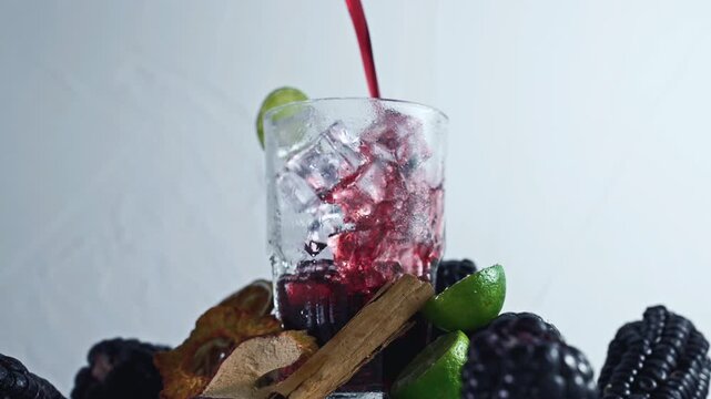 Pouring Chicha Morada, Purple Corn Drink with Lime and Cinnamon