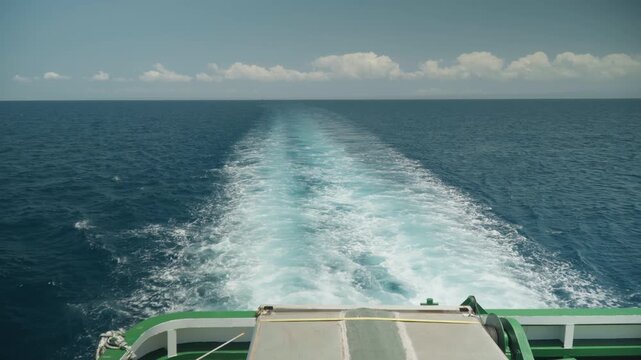 Ship stern wake across deep blue, ocean horizon under soft clouds, aft deck rail visible, churning turquoise trail and white foam, sunlight glinting on waves, calm adventurous mood