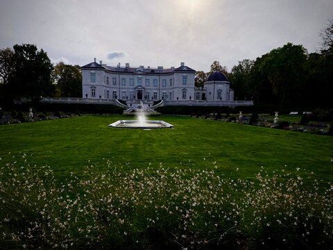 Palanga Amber Museum in Lithuania is set within a sprawling garden. The neoclassical building features a symmetric fa&ccedil;ade with elegant windows and a dome on the right side.