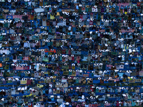 Aerial view of people gathered for the Eid Al-Adha prayer on colorful mats arranged in rows in Kecamatan Kalikajar, Jawa Tengah, Indonesia.