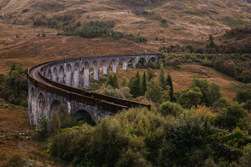 Naklejka premium The historic Glenfinnan Viaduct surrounded by lush green hills, Scottish Highlands