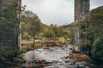 Naklejka premium The historic Glenfinnan Viaduct surrounded by lush green hills, Scottish Highlands