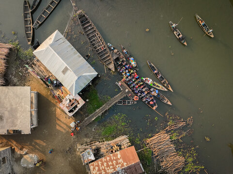 Aerial view of the stilt village with wooden boats and people on the water in Ganvie, Atlantique, Benin.