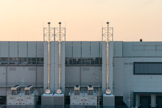 Aerial view of Atman DC WAW-3 data center featuring modern industrial architecture, cooling units, and exhaust stacks in Duchnice, Wojewodztwo mazowieckie, Poland.