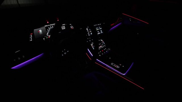 Hybrid electric car Interior view in the cabin. Car interior from driver seat view. Black leather cockpit with ambient light. Cockpit with exclusive decoration. Touch panel climate control