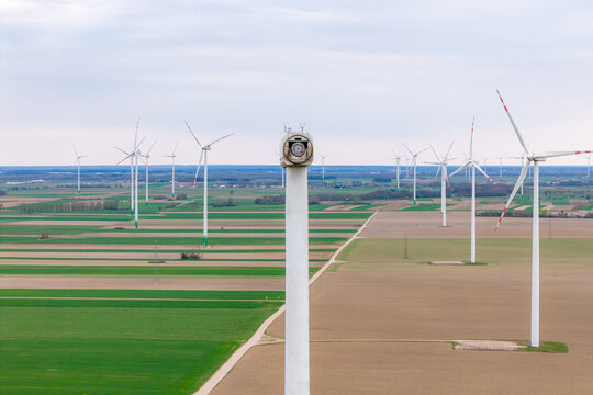 Aerial view of a wind farm with a turbine nacelle missing its blades over vast agricultural fields under an overcast sky in Zielona, Masovian Voivodeship, Poland.