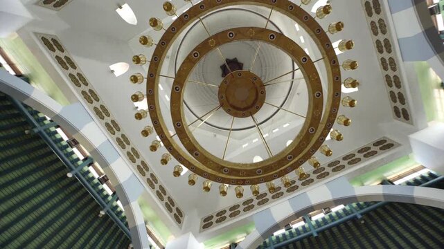 Stunning architectural ceiling with a large circular chandelier and design.