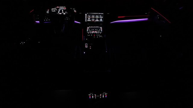 Hybrid electric car Interior view in the cabin. Black leather cockpit with ambient light. Car interior from driver seat view. Cockpit with exclusive decoration. Touch panel climate control.