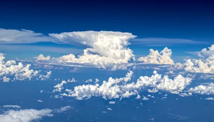 Cumulonimbus cloud formation against a deep blue sky, cumulus clouds below, atmospheric vista, weather patterns © Iman
