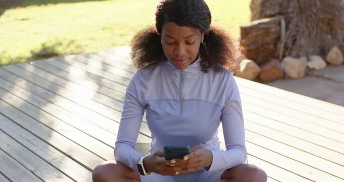 Woman in purple shorts holding phone, scrolling, laughing after seeing message on green mat on deck