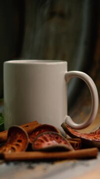 Cozy steaming hot herbal tea mug with cinnamon and bael fruit slices