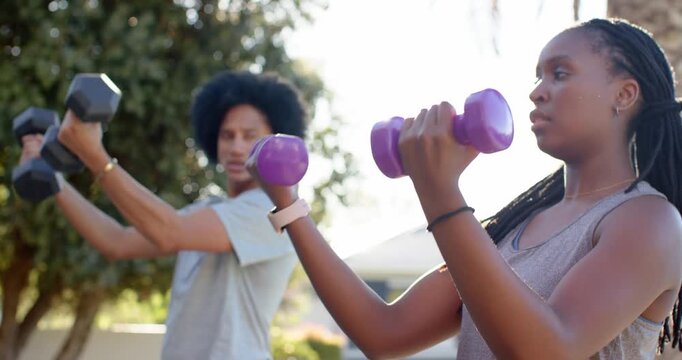 African friends starting chest hold, lifting purple and black hex dumbbells for strength on patio