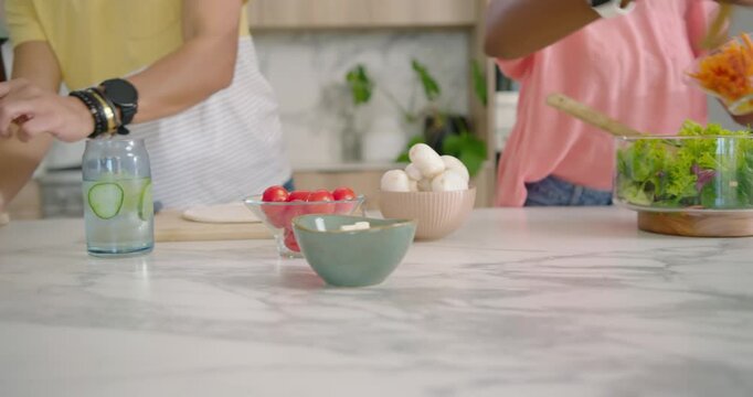 Family starting after prep, chopping veggies, assembling wraps and tossing salad preparing meal