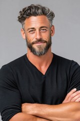 Fototapeta premium Confident mature man portrait with beard and gray hair smiling in casual black sweater, studio close-up