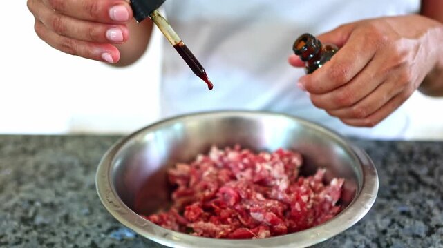 Person adding nutritional supplement to raw dog food
