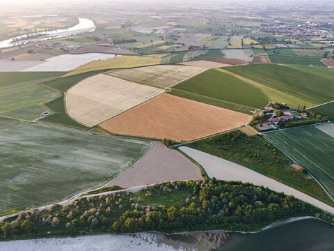 Aerial view of the Basso Lodigiano landscape featuring cultivated fields, green meadows, and the Po River under soft morning light Guardamiglio, Lombardy, Italy.