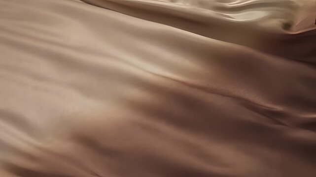 Abstract flowing brown fabric texture with soft light reflections.