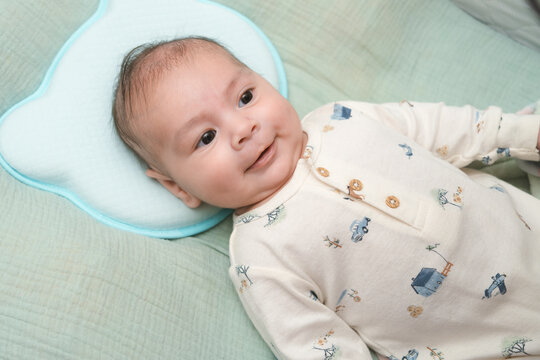 Beb&eacute; sonriente acostado en su cuna