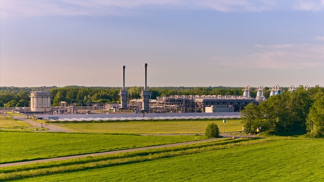 Aerial view of the primary natural gas storage facility with industrial stacks and pipelines surrounded by green fields Langelo, Drenthe, Netherlands.