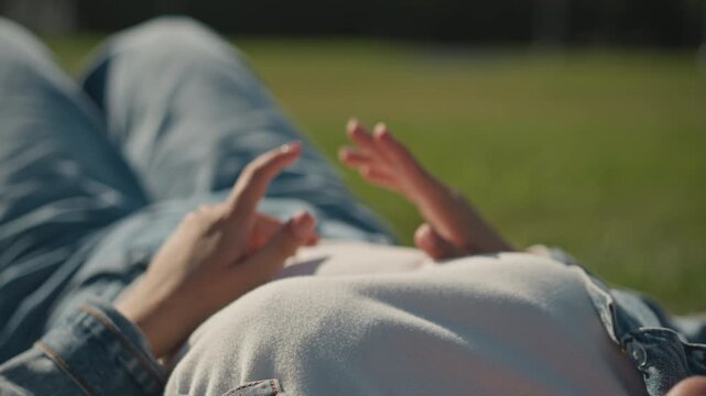 Calm fingers dance in grassy field. Peaceful scene with hands hovering and sunlight glowing softly. Relaxed hands move gracefully above grass amid tranquil sunlight and outdoor serenity