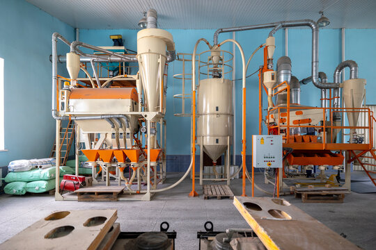An industrial aggregate unit designed for grain processing and groats enrichment stands inside a production facility used for the purification of millet corn groats and other grain crops
