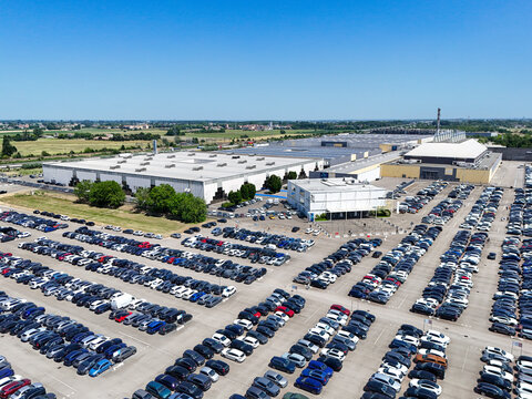 Parma, Italy - 26 May 2026: Aerial view of Fiere di Parma exhibition center with large parking lots filled with cars under a clear blue sky.