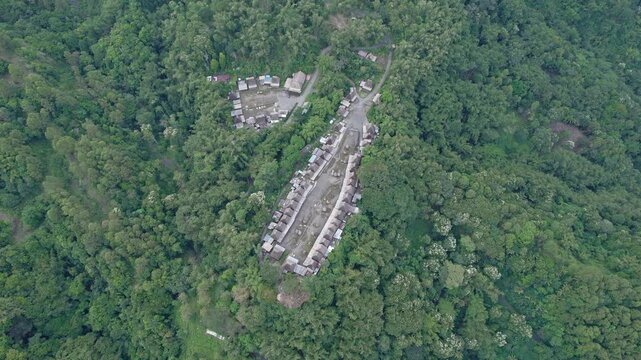 Aerial view of Bena Traditional Village with its iconic thatched roof houses nestled in dense tropical forest in Kecamatan Jerebuu, Nusa Tenggara Timur, Indonesia.
