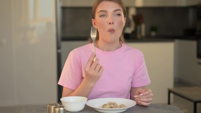 Young Woman Engaging In Tasting Dumplings With Focused Expression In Wellequipped Modern Kitchen Setting