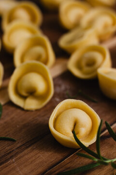 Fresh homemade cappelletti pasta close up on dark rustic wooden board
