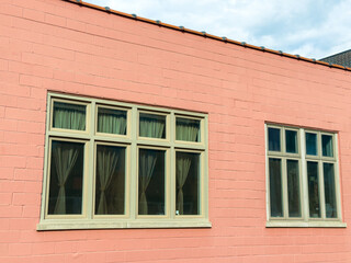 Obraz premium Building with pink wall and windows in urban area during daytime with clouds