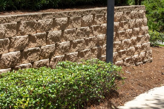 Stone retaining wall sorrounded with bushes
