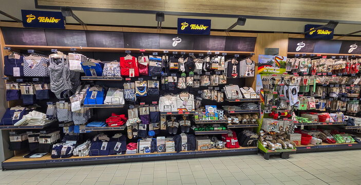 Uberlingen, Germany - May 28, 2026. Interior of a modern grocery store Edeka featuring a dedicated Tchibo merchandise section with clothing and accessories of German National Team Fan Gear.