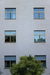 Obraz premium Modernist apartment building facade with asymmetric yellow windows, 35mm film photography