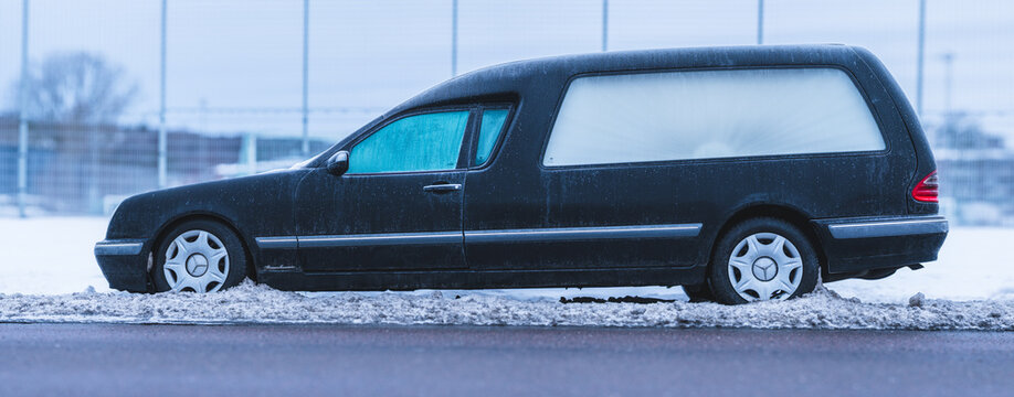 Gothenburg, Sweden - February 22 2026: Black Mercedes Benz E Class hearse parked on snowy roadside in winter.