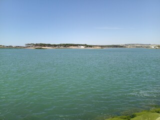 Naklejka premium Green Algae Rocks and Calm Turquoise Waters on a Sunny Day