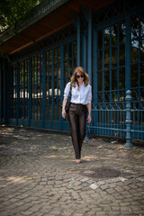 Fototapeta premium Elegant mature business woman walking outdoors in stylish urban setting