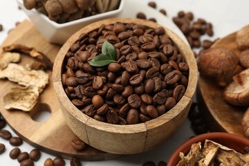 Fototapeta premium Coffee beans and mushrooms on white table, closeup