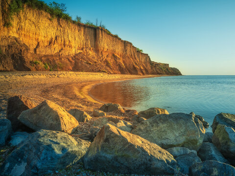 golden light of rising sun on stones and cliff