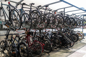 London, UK, 3 May 2026,  Two-tier metal bicycle rack filled with numerous parked bikes under a...