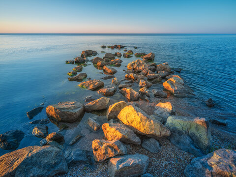 group of stones at sea in first light of sun