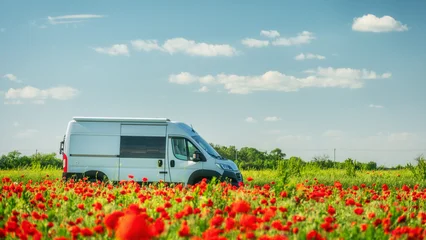 white camper van in poppies field in summer day © sergejson