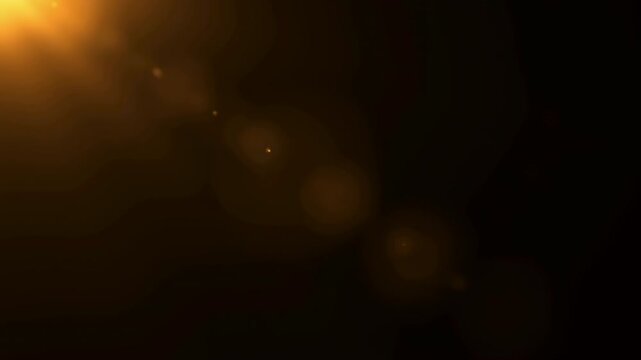 Golden optical lens flare light leak overlay on black background